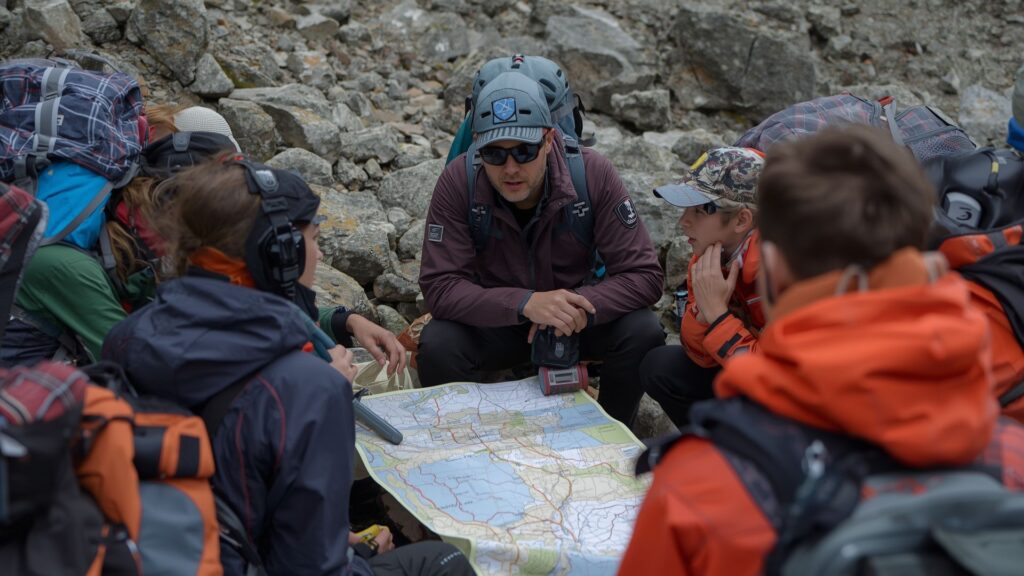 Effective teams practicing clear communication during mountain expedition briefing with guide
