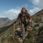 Hiker using hiking poles on Irish mountain trail with proper technique