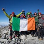 Pat Falvey adventure show reel hero image showing summit celebration with expedition team on mountain peak