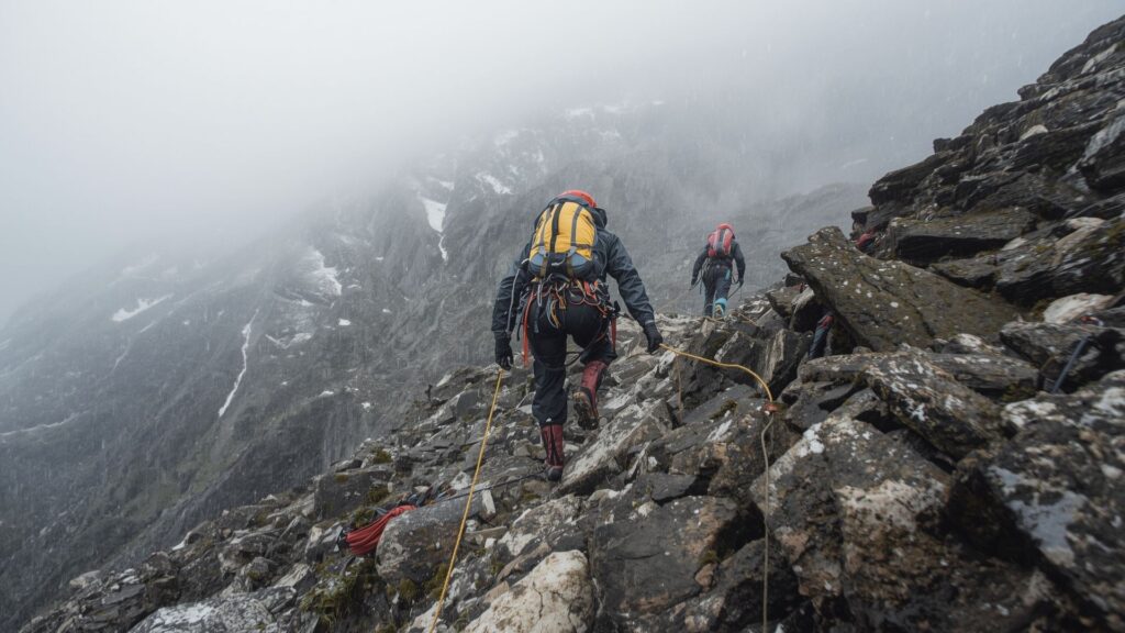 Mountaineers overcoming difficult obstacles while achieving your goals during challenging expedition in harsh mountain conditions