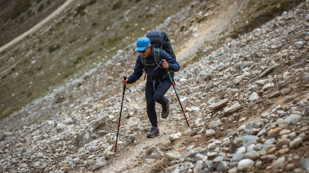 Tips for trekking safety showing proper walking pole technique during steep mountain descent