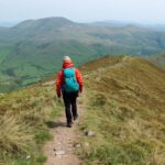 Hill walking for beginners starting their first trail in Irish mountains with proper hiking gear and day pack