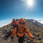 Kilimanjaro FAQs guide showing trekkers ascending Africa's highest peak with mountain views