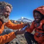 Kilimanjaro health and safety guide monitoring climber oxygen levels at high altitude camp